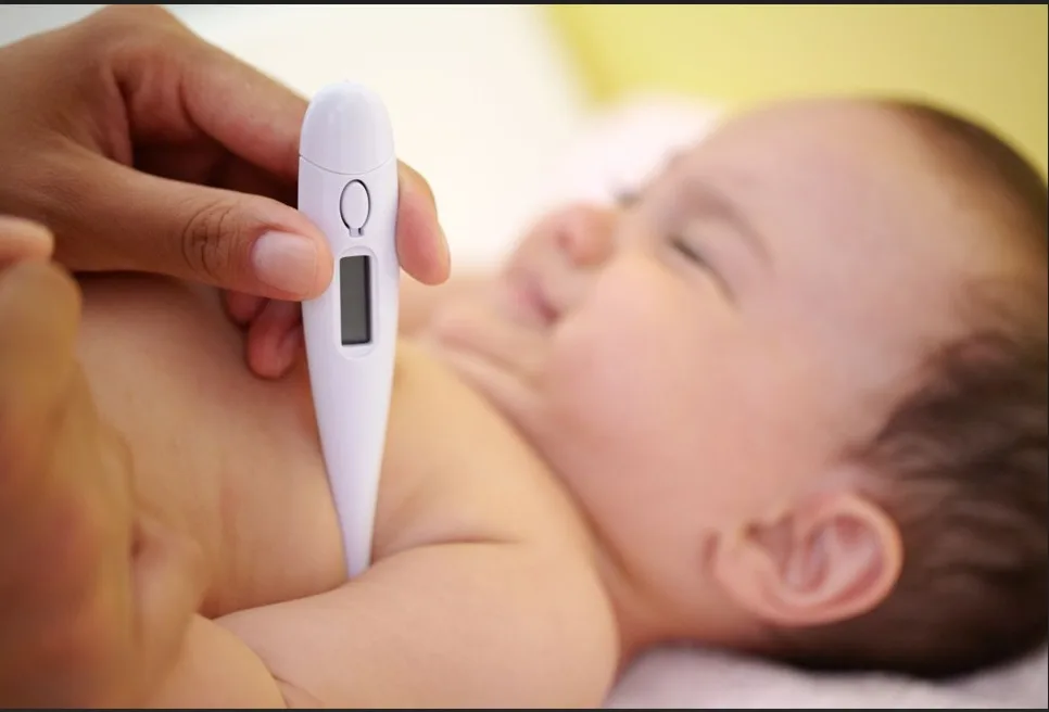 A parent watching over a sick baby who has a recurring fever