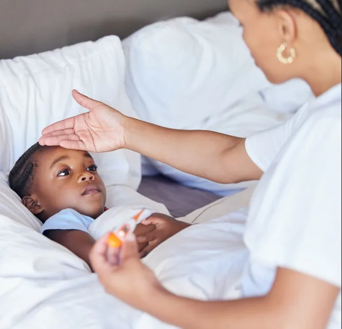 A baby with a fever being checked with a thermometer