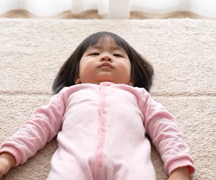 A baby appearing stiff and unresponsive during a fever spike